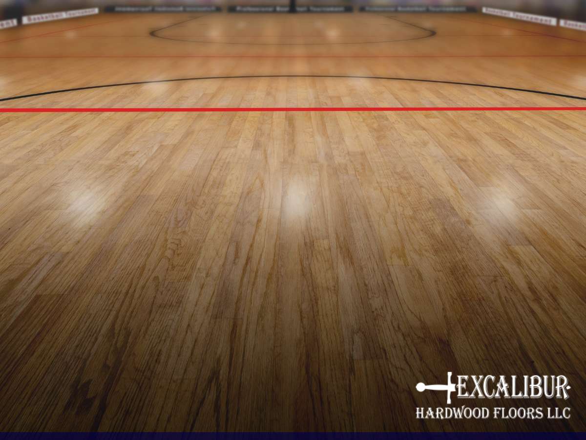 Polished gym floor with Excalibur Hardwood Floors LLC logo in the corner