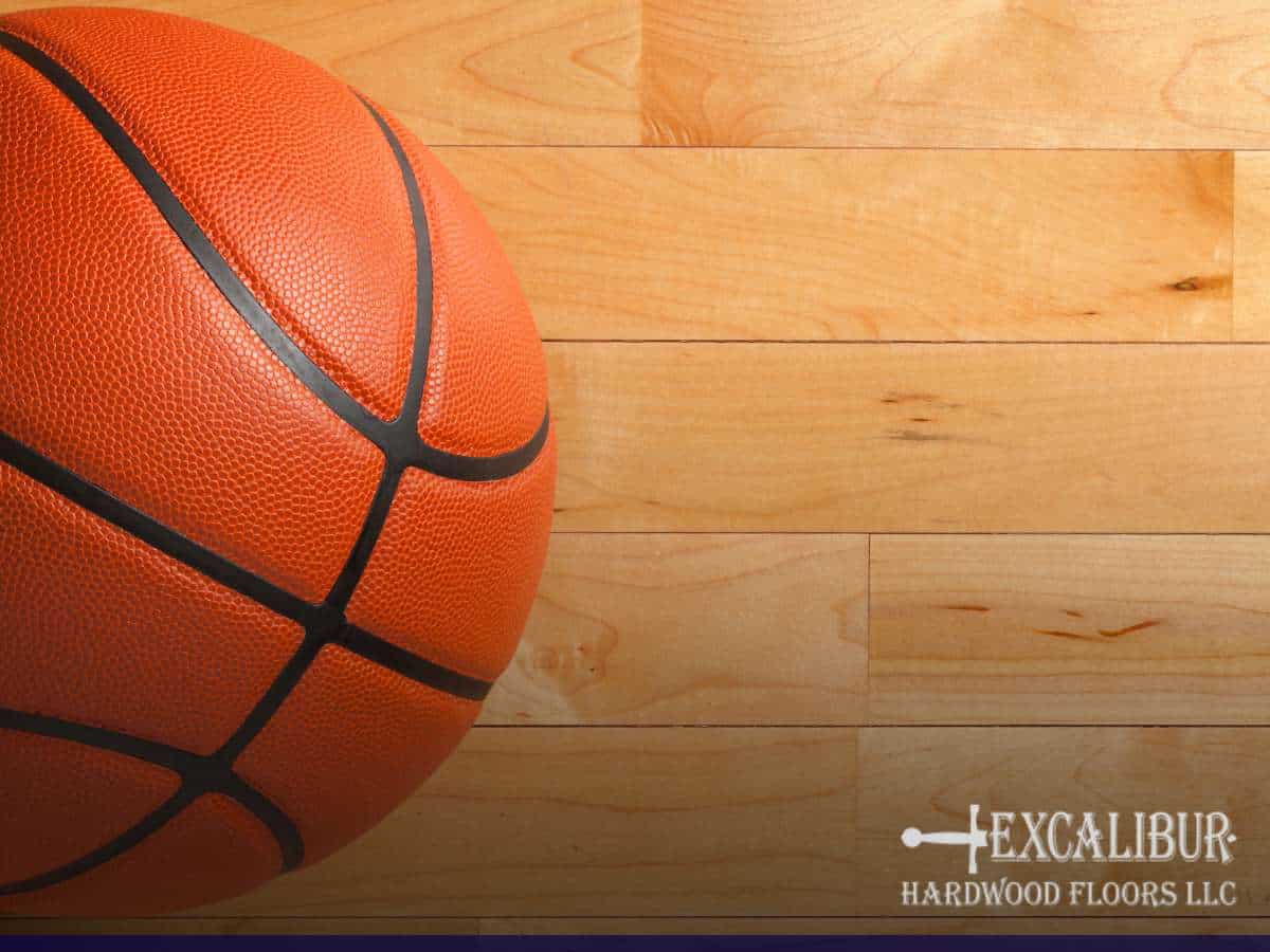 Basketball on a hardwood floor, showcasing the results of a screen & coat for gym floors by Excalibur Hardwood Floors