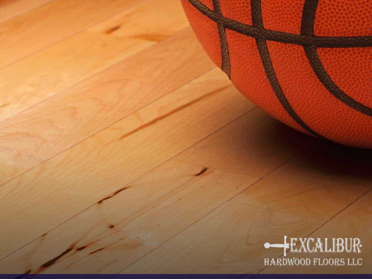 Basketball resting on polished Maple Hardwood gym flooring by Excalibur Hardwood Floors