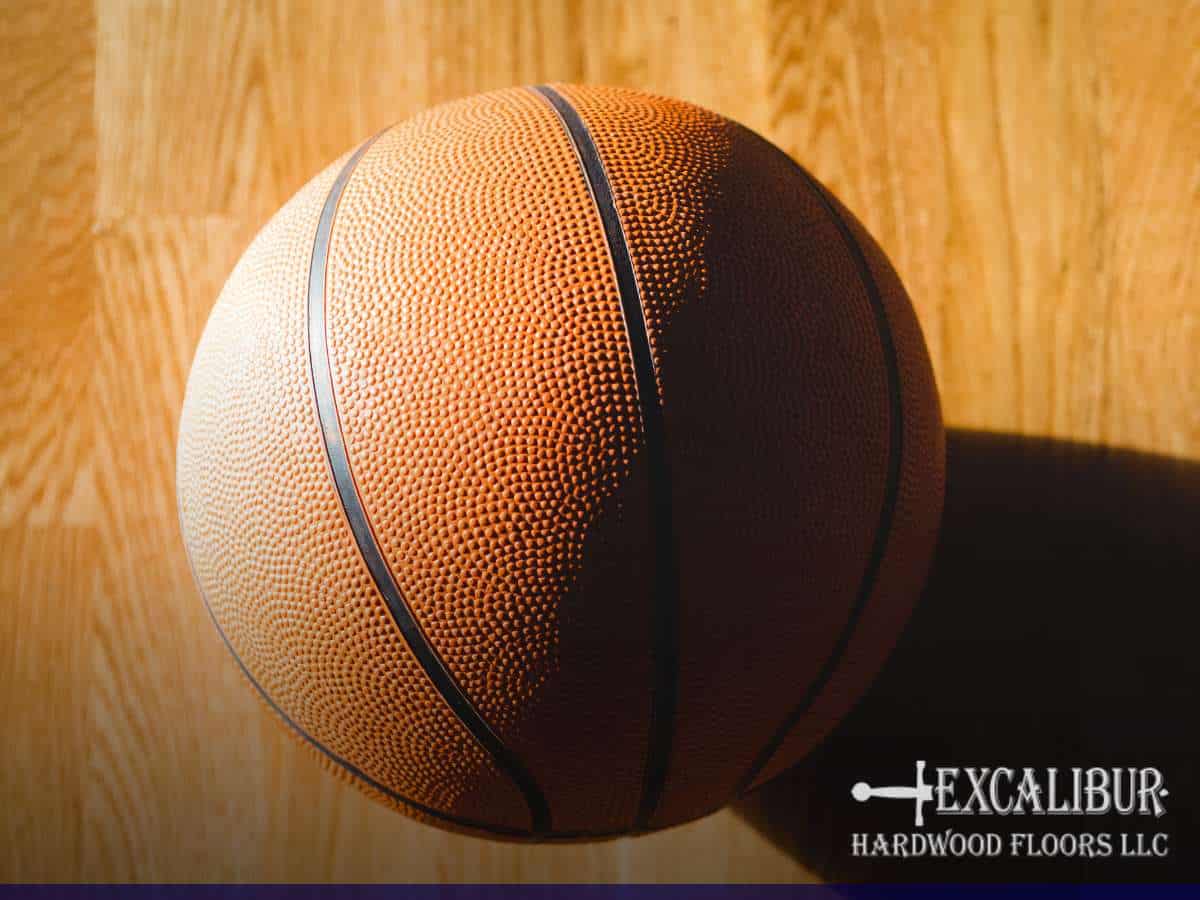 A basketball resting on a polished gym floor, highlighting its smooth and durable hardwood surface