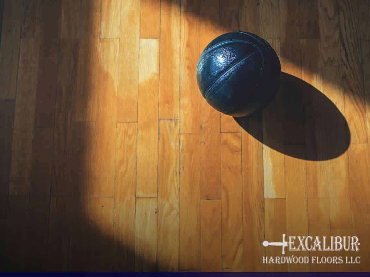 Hardwood gym floor with basketball, showcasing quality installation